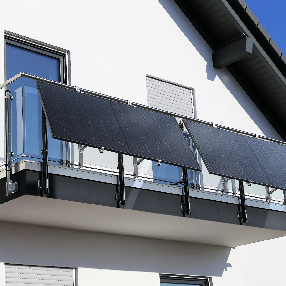 Balkonkraftwerk mit zwei Solarmodulen an einem Glasgeländer montiert – platzsparende Mini-PV-Anlage zur Stromerzeugung direkt am Balkon.