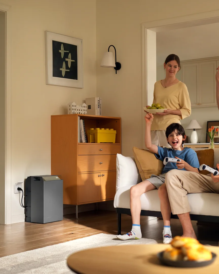 Familie im Wohnzimmer, daneben ein EcoFlow-Speicher an der Steckdose