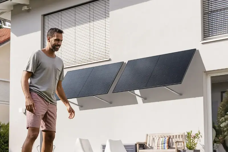 Zwei vertikal an der Hausfassade montierte Balkonkraftwerk-Solarmodule unter einem Fenster – platzsparende Mini-PV-Anlage für nachhaltige Stromgewinnung an der Wandfläche.